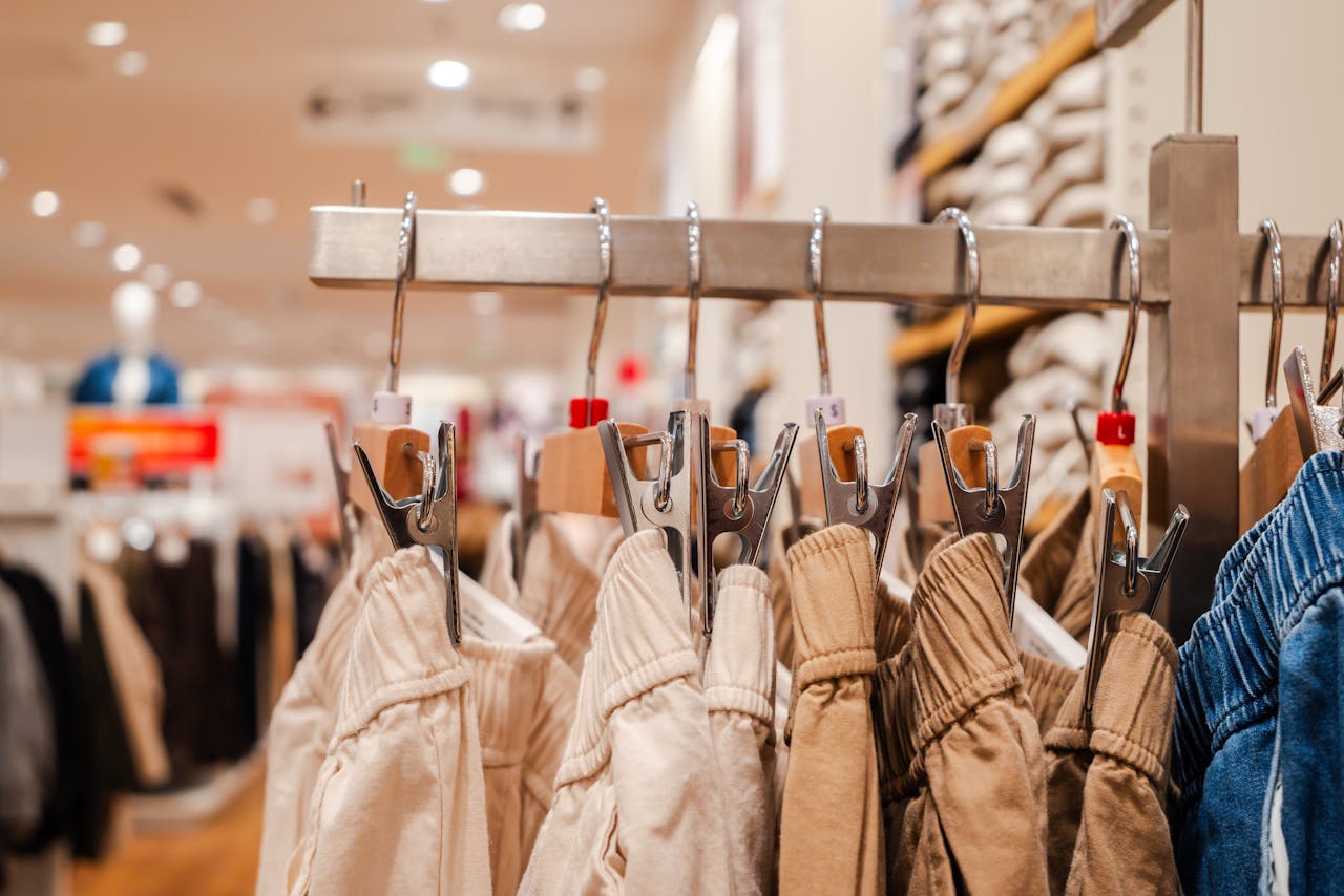 services-02 Detail shot of trousers on hangers in a clothing store, highlighting fashion trends.